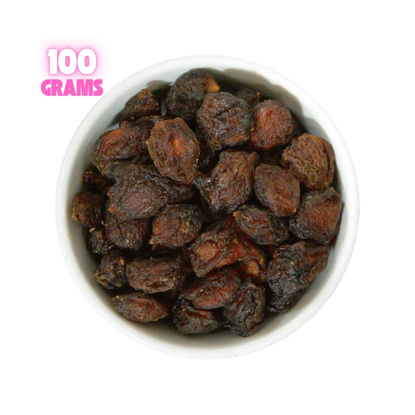 White bowl filled with 100 grams of dried dark brown apricots on white background