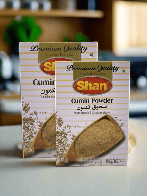 Two boxes of Shan Cumin Powder with wooden spoon and cumin seeds, premium quality spice packaging