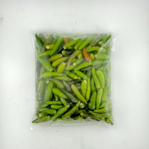Vacuum-sealed plastic bag of fresh green chili peppers with a few red chilies on white background