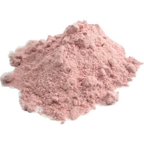 Pile of fine pink powder on white background, close-up texture detail