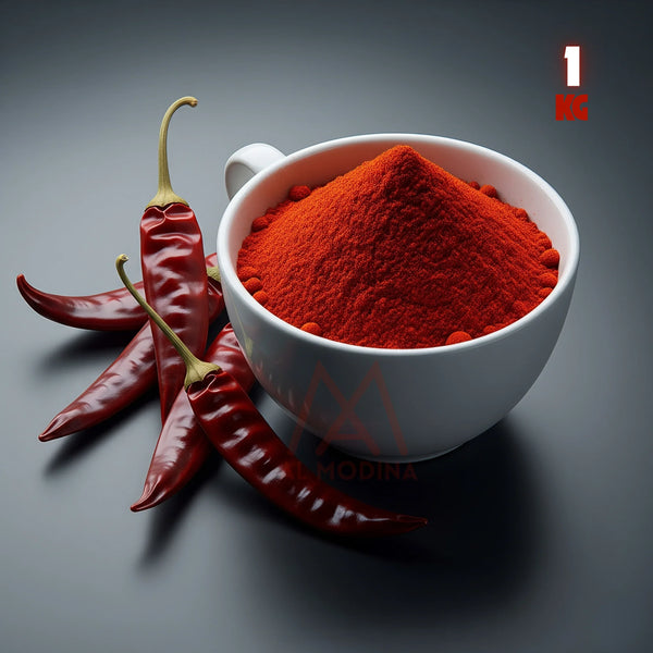 White cup filled with red chili powder surrounded by whole dried red chili peppers on gray surface
