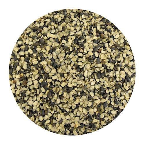 Close-up of dried black and white split urad dal pulses in a round container