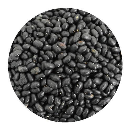 Close-up of shiny black beans with smooth texture filling a round container