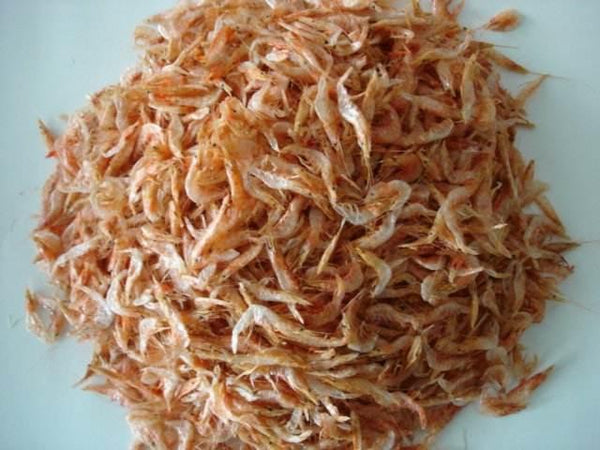 Pile of dried small shrimp seafood on white surface