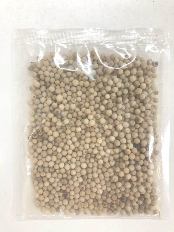 Clear plastic bag filled with white peppercorns on a white surface