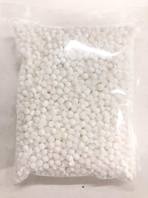 Clear plastic bag filled with small white granules on a light surface
