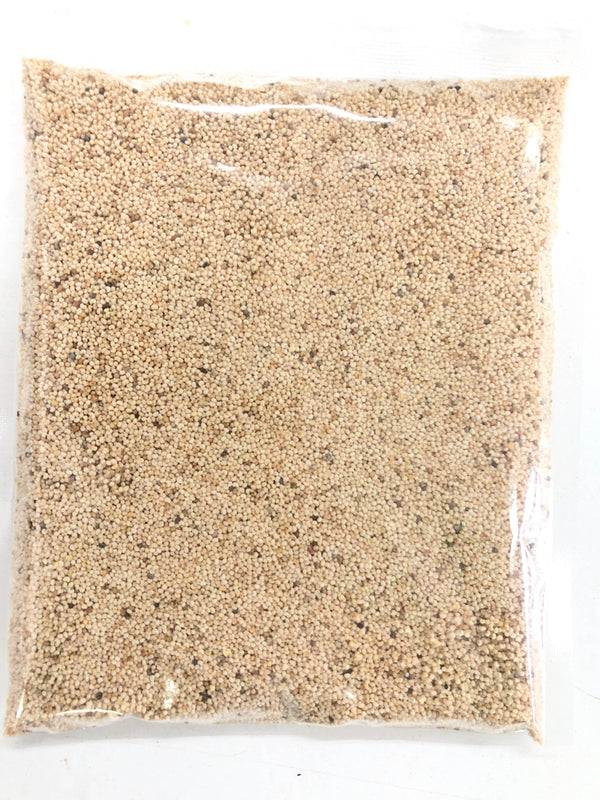 Clear plastic bag filled with small beige and brown granular seeds on white background