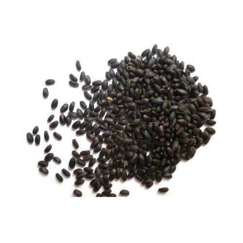 Close-up of black watermelon seeds scattered on a white background