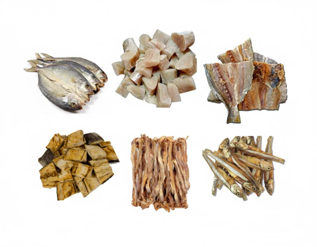 Variety of dried fish products including whole, sliced, and small dried fish pieces on white background
