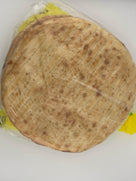 Pack of round grilled flatbread wrapped in clear plastic on white surface