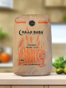 Hajji Baba Chakki Fresh Atta 5kg brown paper bag with wheat illustration on kitchen counter