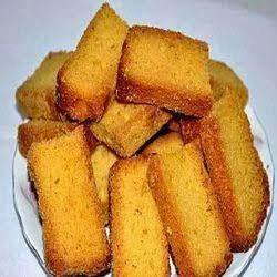 Plate of golden brown toasted bread slices stacked neatly on a white surface