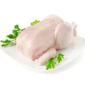 Raw whole chicken on white plate garnished with fresh parsley
