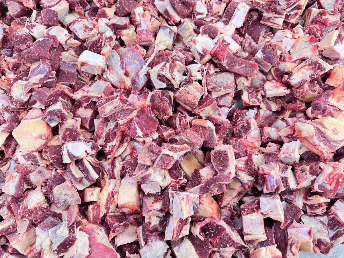 Close-up of numerous raw beef pieces with fat, ideal for stews or soups
