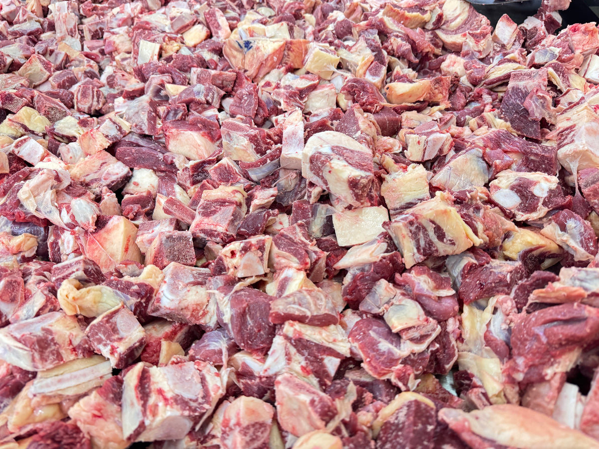 Close-up view of fresh raw beef chunks with fat and connective tissue