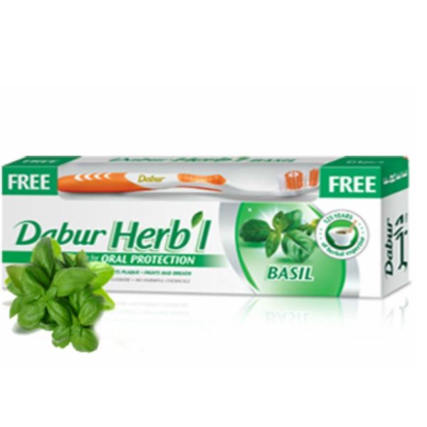 Dabur Herb'l Basil toothpaste box with fresh basil leaves and an orange toothbrush included for oral protection
