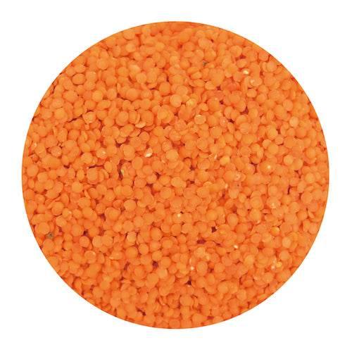 Close-up of orange lentils texture, small round dry pulses packed tightly