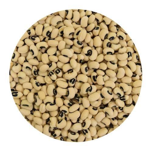 Close-up of black-eyed peas beans filling a circular frame, showing beige pods with distinctive black eye markings