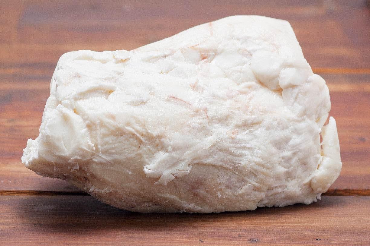 Large piece of white raw pork fat on wooden surface