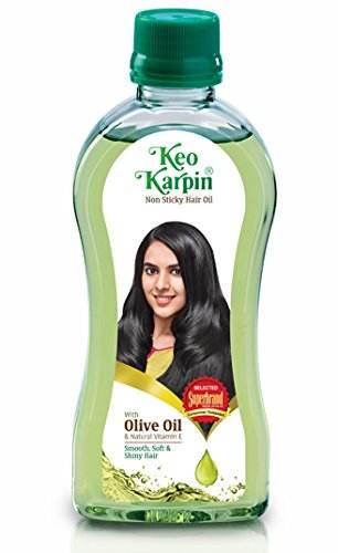 Bottle of Keo Karpin Non Sticky Hair Oil with olive oil and natural vitamin E, featuring a smiling woman with long black hair on label