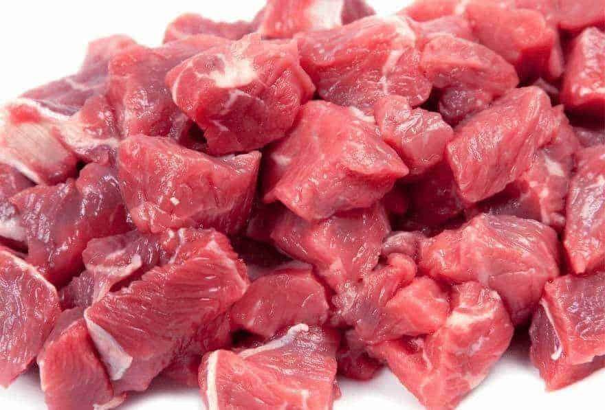 Close-up of fresh cubed boneless beef meat with a rich red color on a white background