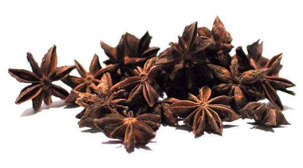 Close-up of dried star anise spice with distinct star-shaped pods on white background