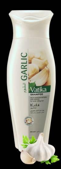 Bottle of Vatika Garlic Shampoo with garlic cloves and green leaves on black background