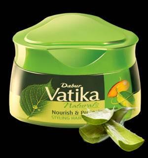 Dabur Vatika Nourish & Protect styling hair cream in green jar with aloe vera leaves on black background