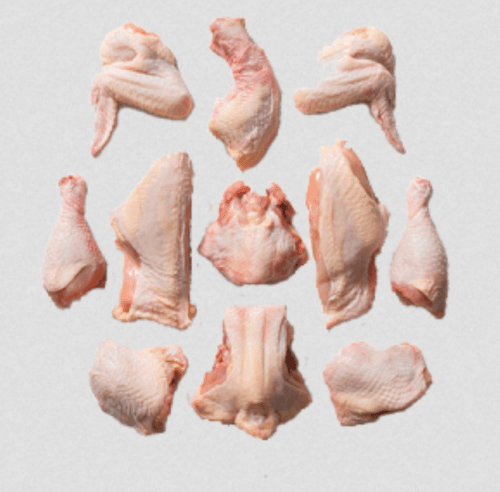Raw chicken cut pieces including wings, drumsticks, and breast on white background