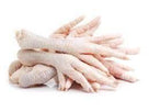 Fresh raw chicken feet stacked on white background for cooking or sale