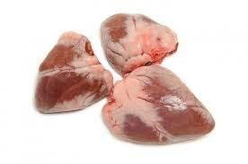 Three raw, cleaned chicken hearts on white background, fresh and ready for cooking