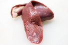 Close-up of raw beef liver on a white surface, showing texture and deep red color