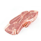 Raw pork chop with bone and marbled fat on white background