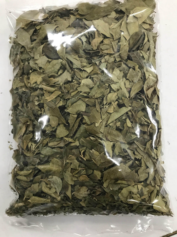 Clear plastic bag filled with dried green curry leaves on a white background