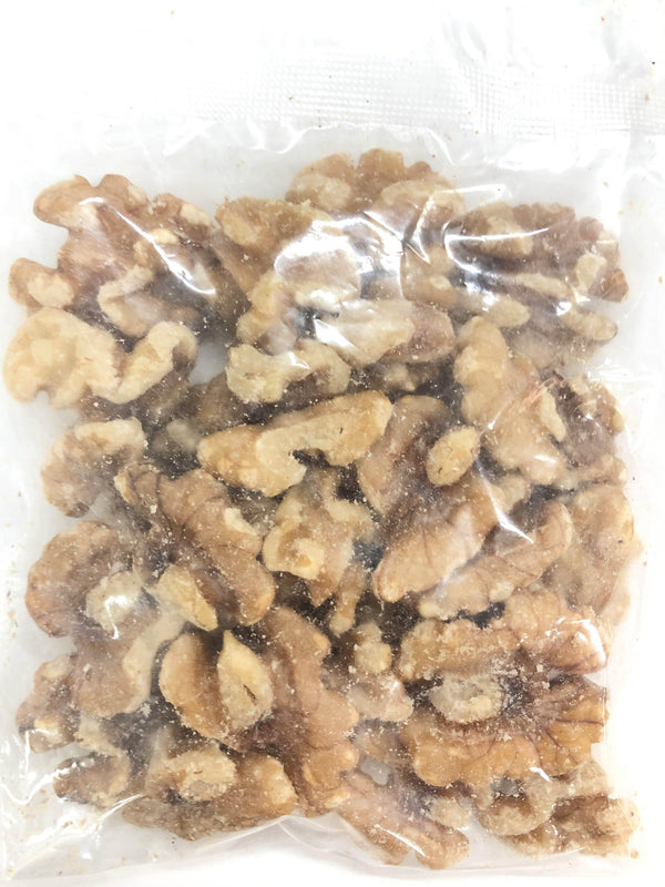 Transparent plastic bag filled with shelled walnut halves and pieces