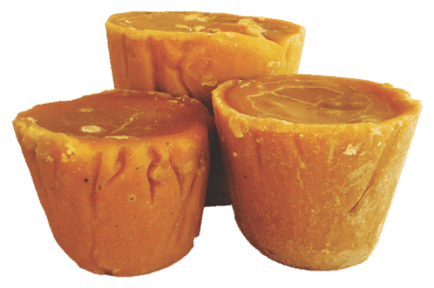 Three solid jaggery blocks with smooth, glossy surfaces stacked together