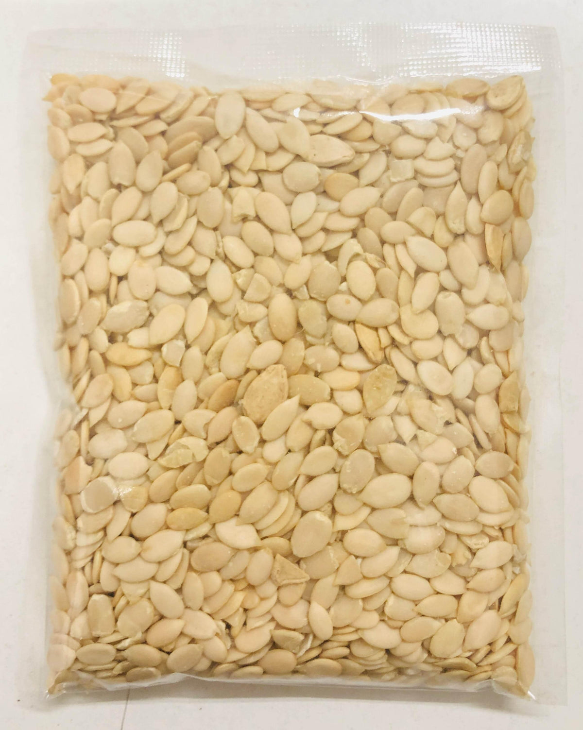 Vacuum-sealed clear plastic bag filled with light-colored melon seeds