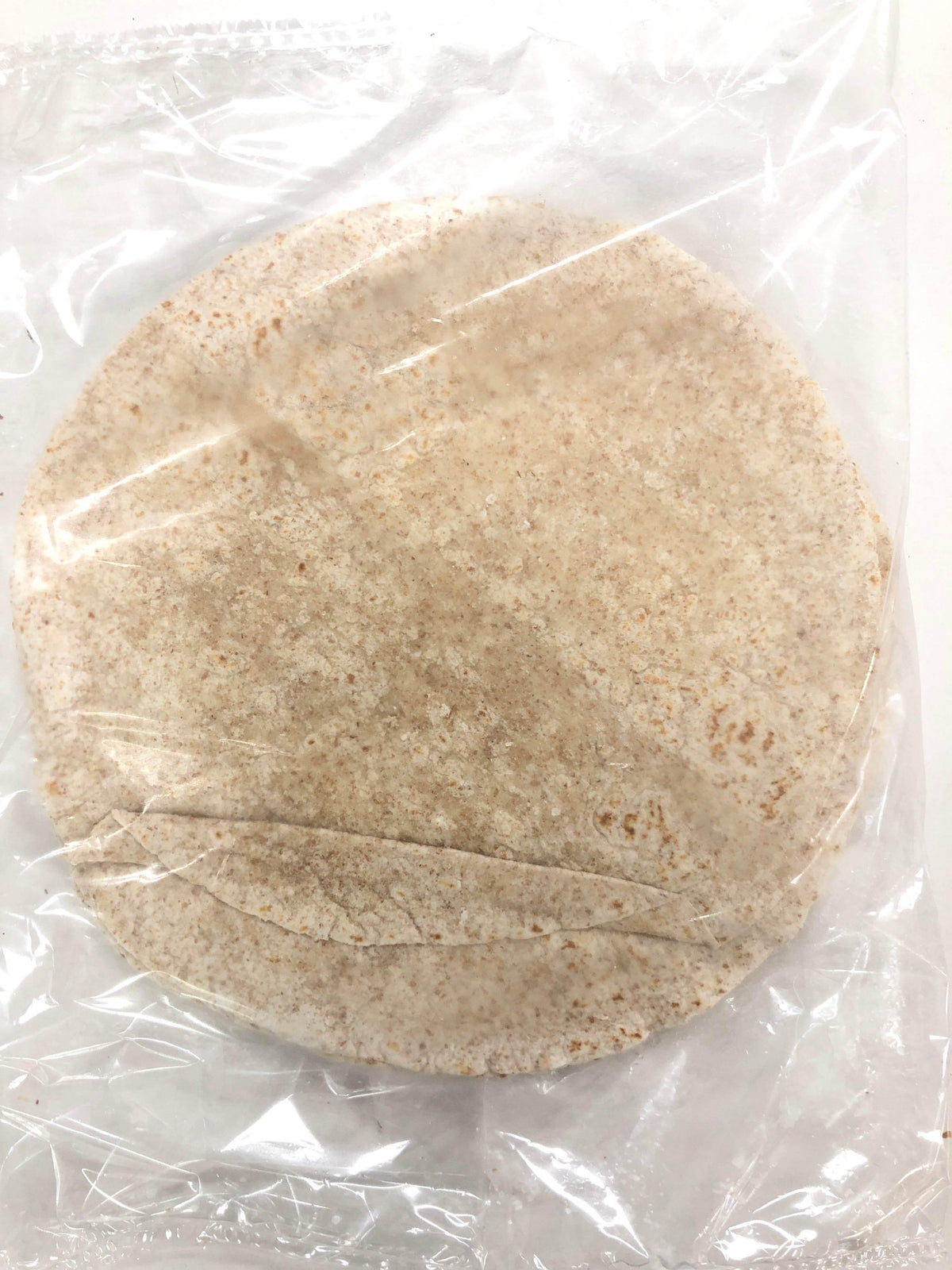 Pack of whole wheat tortillas in clear plastic packaging on white background