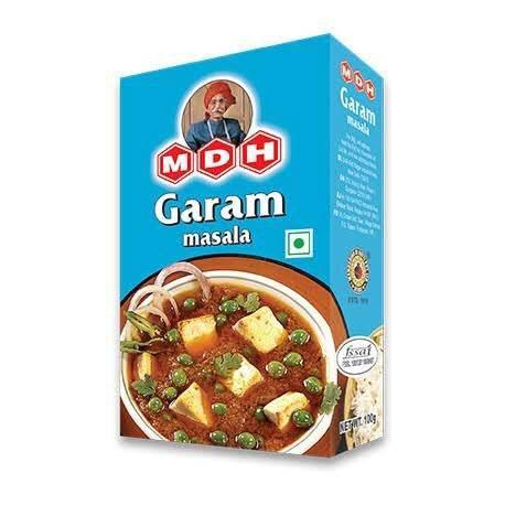 MDH Garam Masala spice mix box with Indian curry dish featuring paneer and peas on blue background