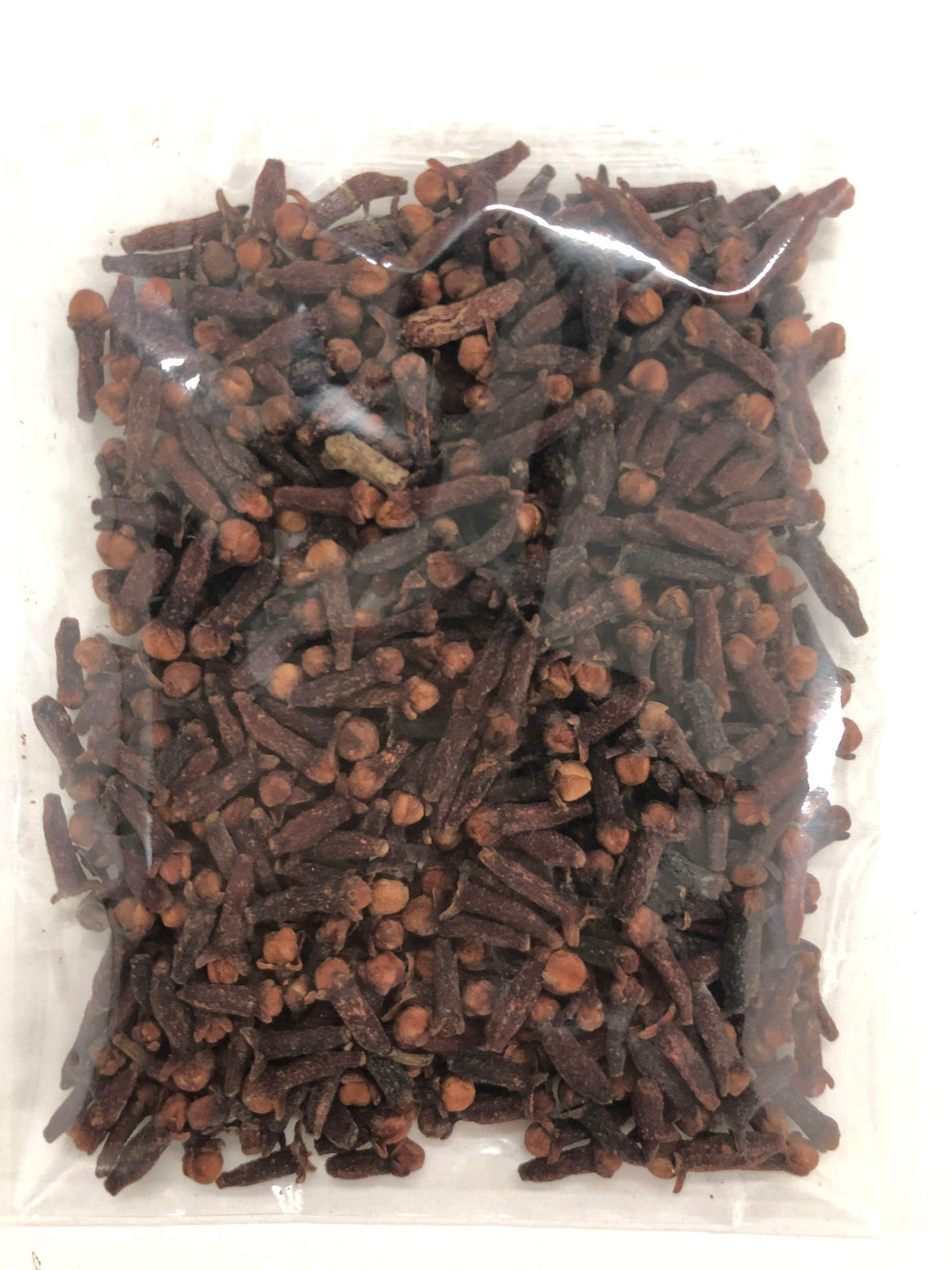 Clear plastic bag filled with dried whole cloves spice