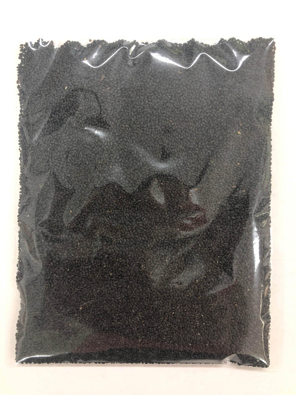 clear plastic bag filled with black sesame seeds on a white background