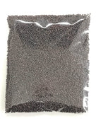 Clear plastic bag filled with tiny round black beads or seeds on a white background