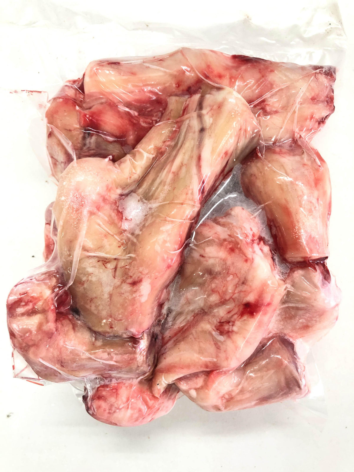 Vacuum-sealed raw pork neck bones with visible marrow and meat texture on white background
