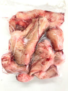 Vacuum-sealed raw pork neck bones with visible marrow and meat texture on white background