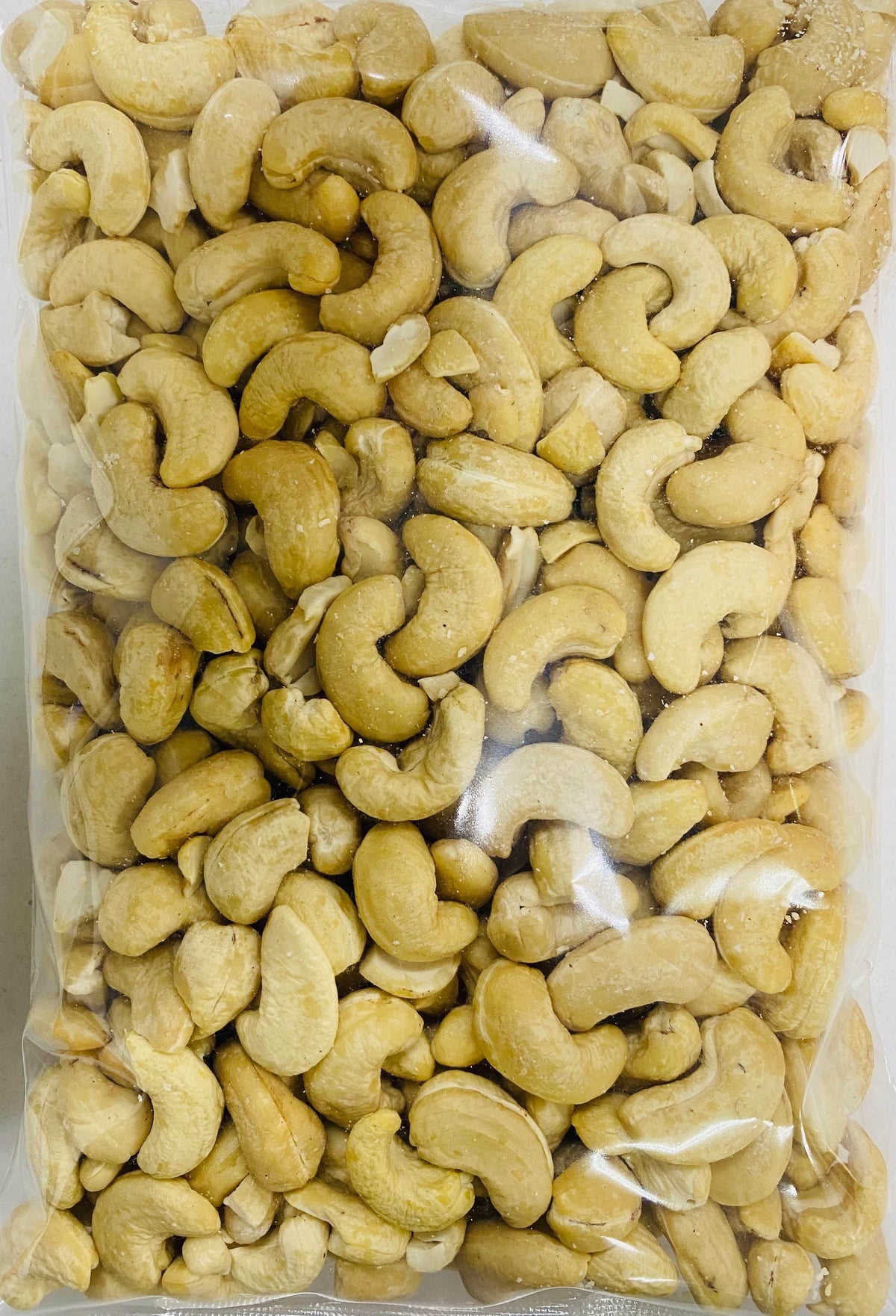 Clear plastic package filled with raw cashew nuts, natural and unroasted