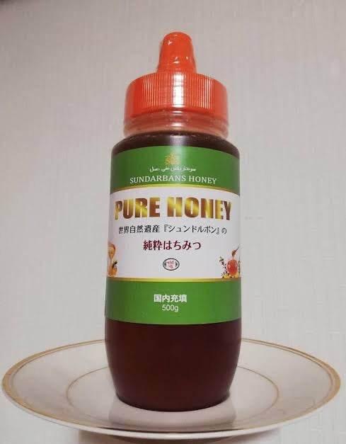 500g bottle of Sundarbans pure honey with green label and orange cap on white plate