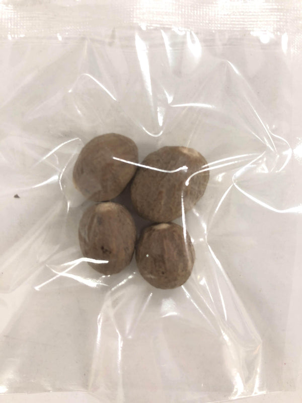 Four whole nutmeg seeds inside a clear plastic vacuum-sealed bag
