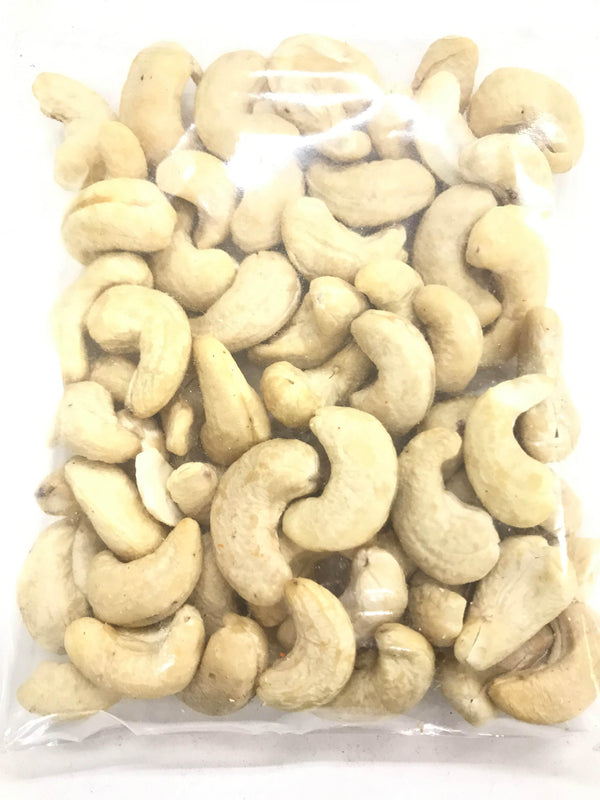 Clear plastic bag filled with whole raw cashew nuts on white background