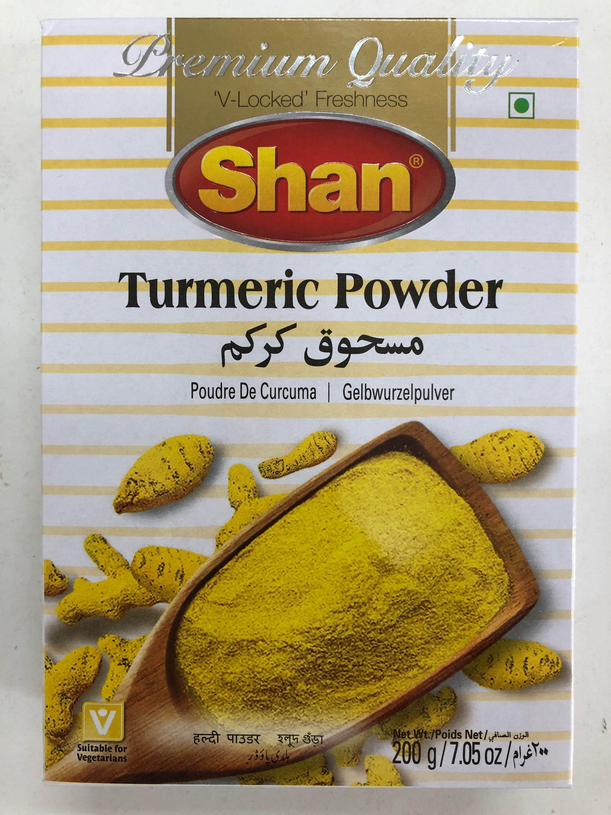 Shan brand turmeric powder 200g box with yellow turmeric roots and wooden scoop on striped background