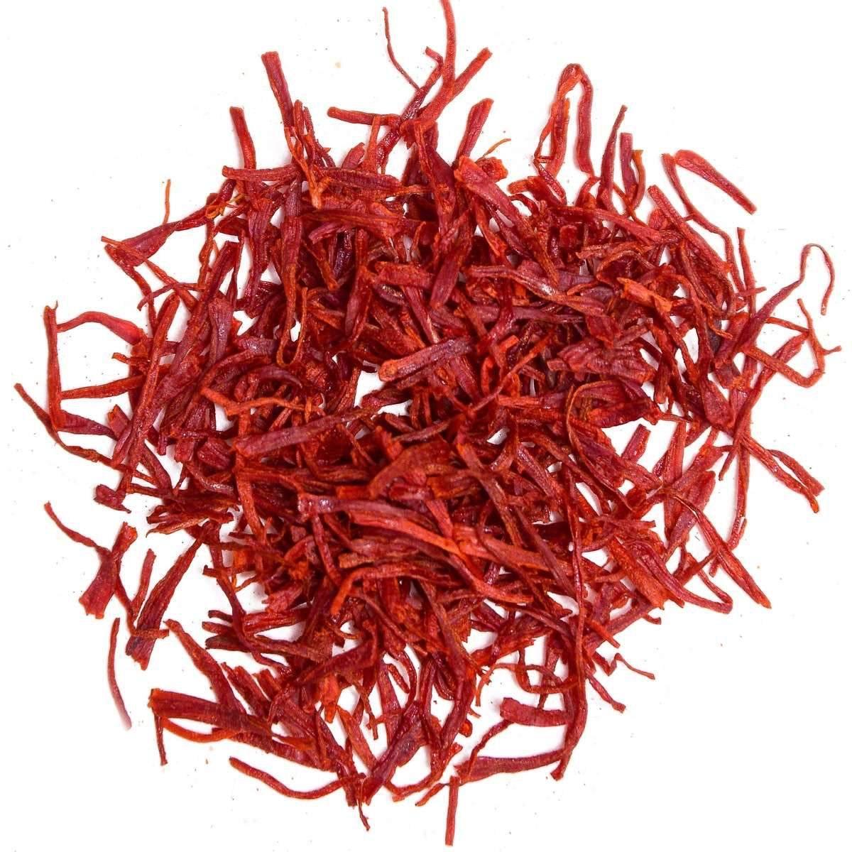 Close-up of vibrant red saffron threads on white background, premium spice strands